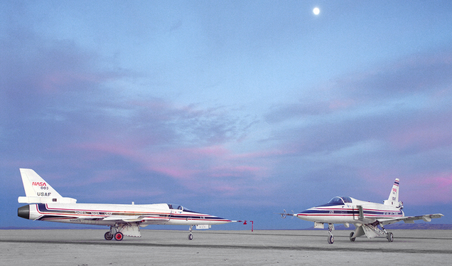 Both X-29 aircraft on Rogers Dry Lake in 1990. The characteristic long pointed nose of the F-5 Freedom Fighter, as well as the splayed main gear of the F-16, can be seen. (NASA)